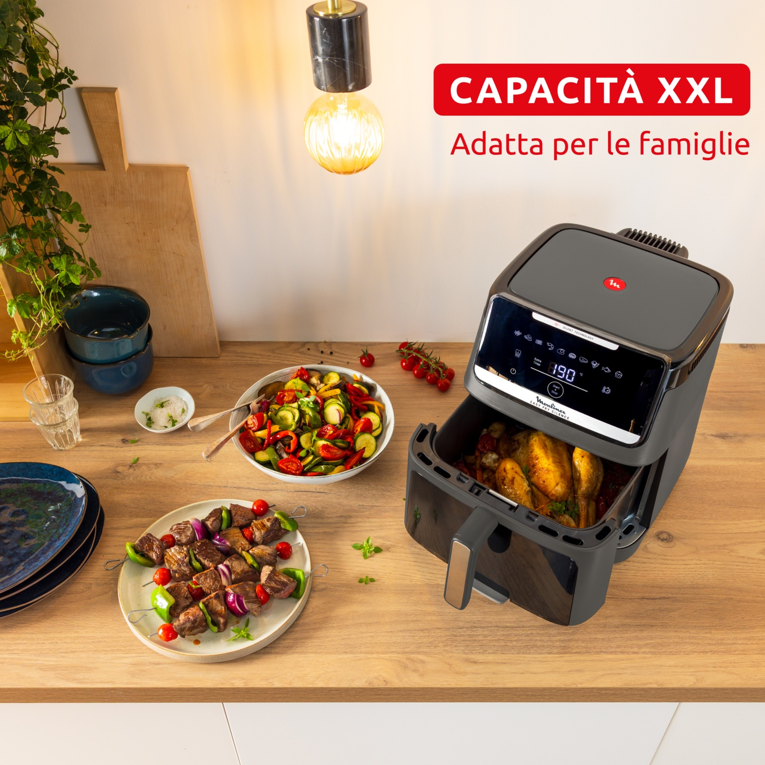 Una friggitrice ad aria con pollo arrosto, spiedini di carne e insalata di verdure.