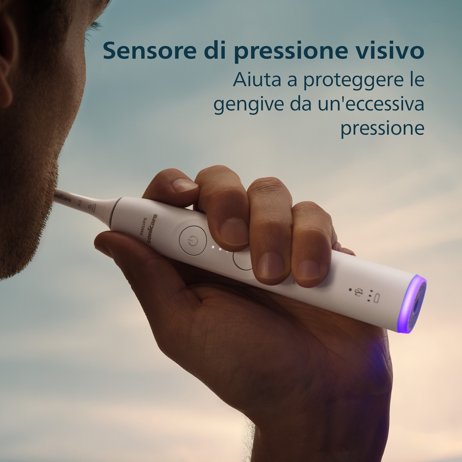Spazzolino sonico bianco con luce blu in basso, tenuto da una mano.