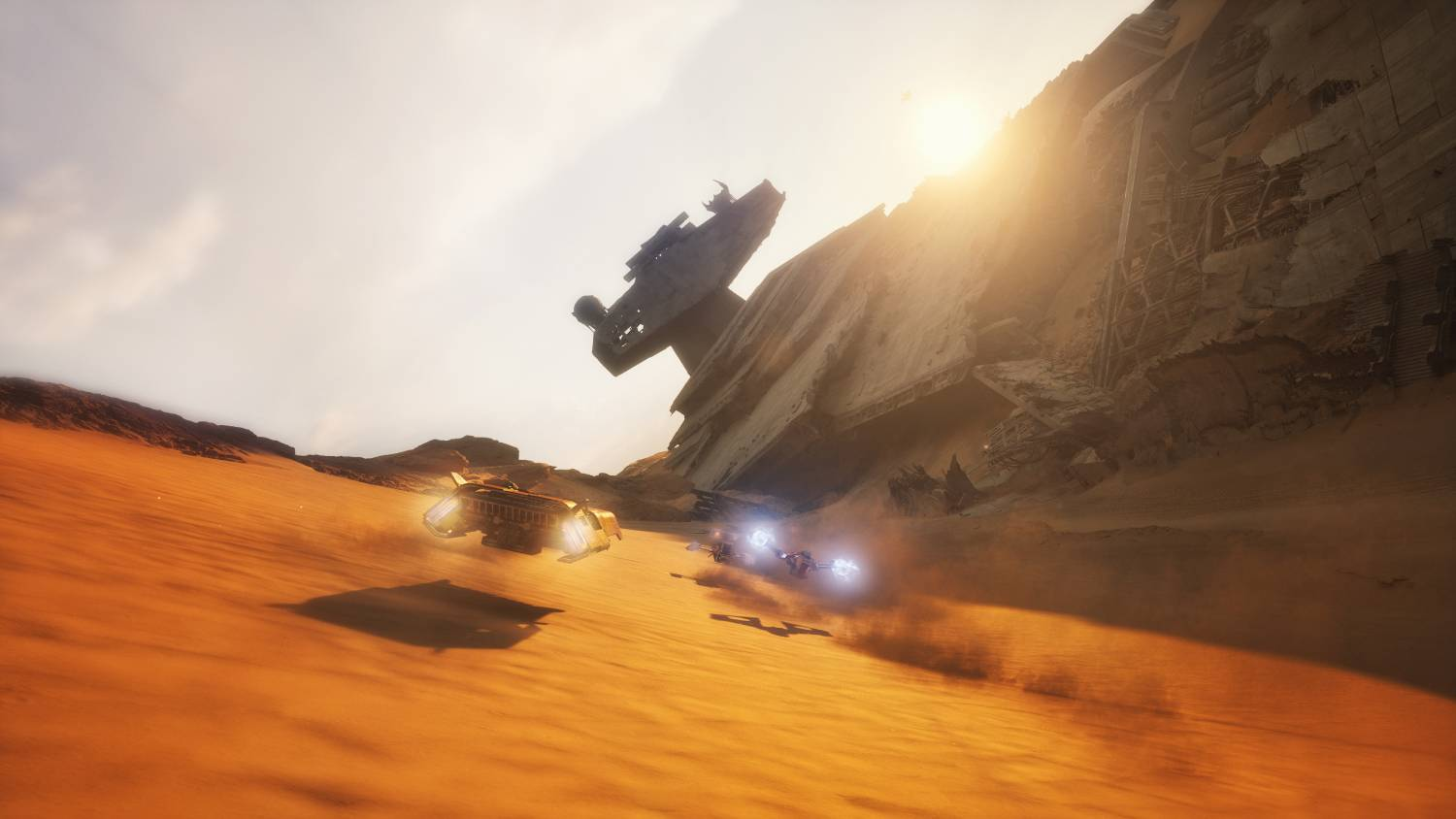 Vehículos compiten por un desierto junto a una nave espacial estrellada.