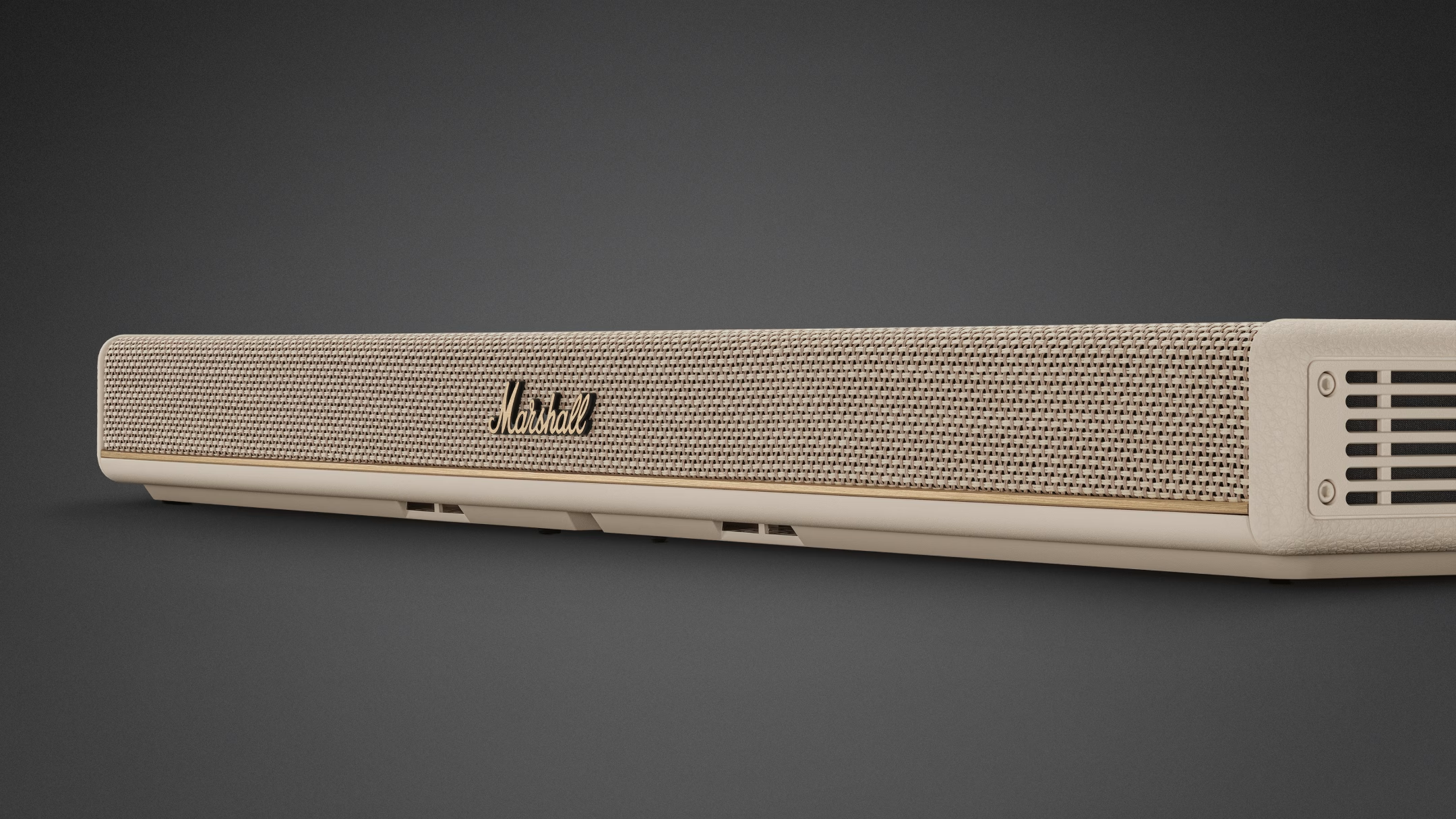 Eine beige Marshall-Soundbar mit goldenem Logo auf grauem Hintergrund.