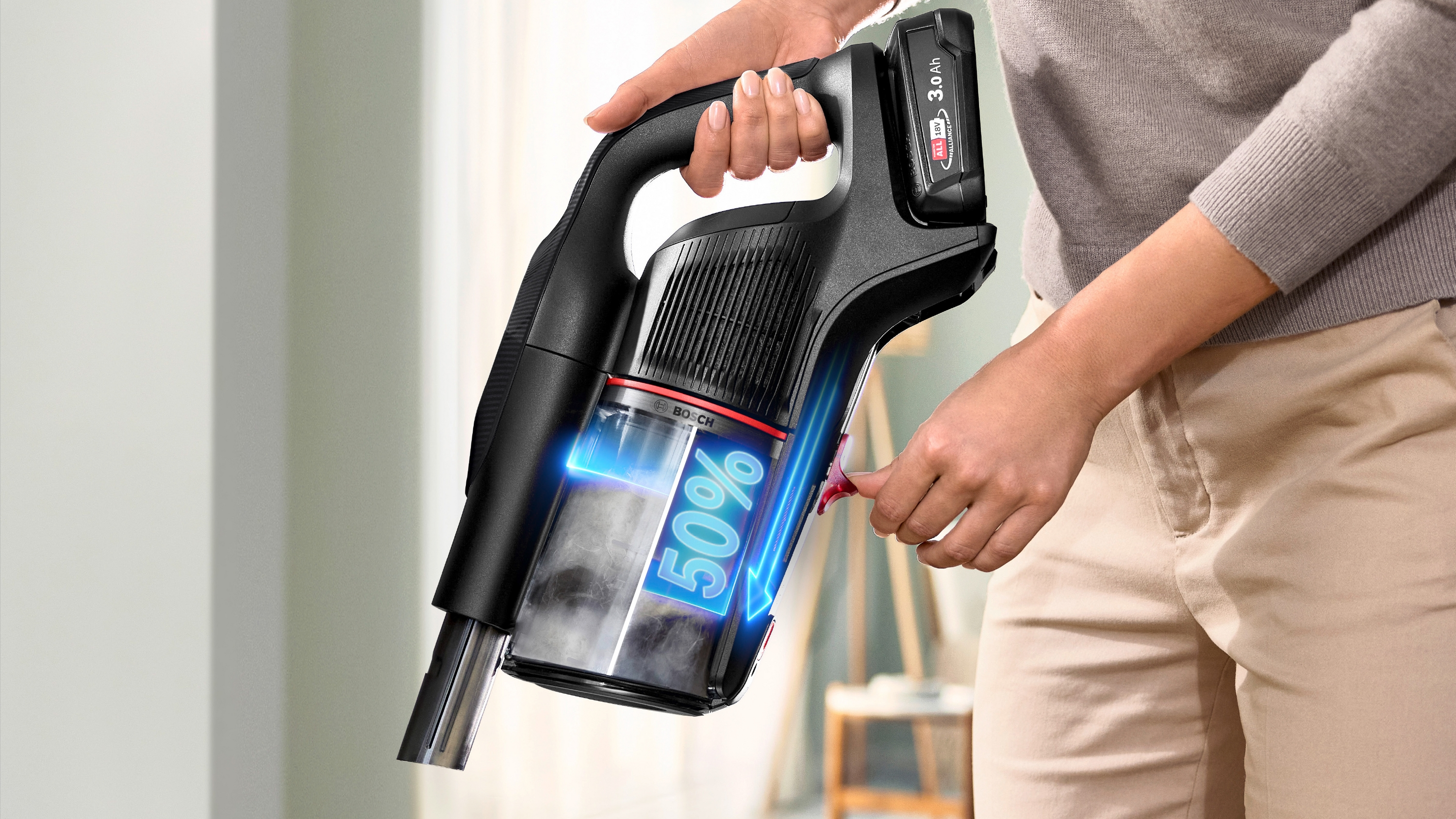 Eine Person hält einen schwarzen Bosch Akku-Staubsauger mit 50% Akkuladung.