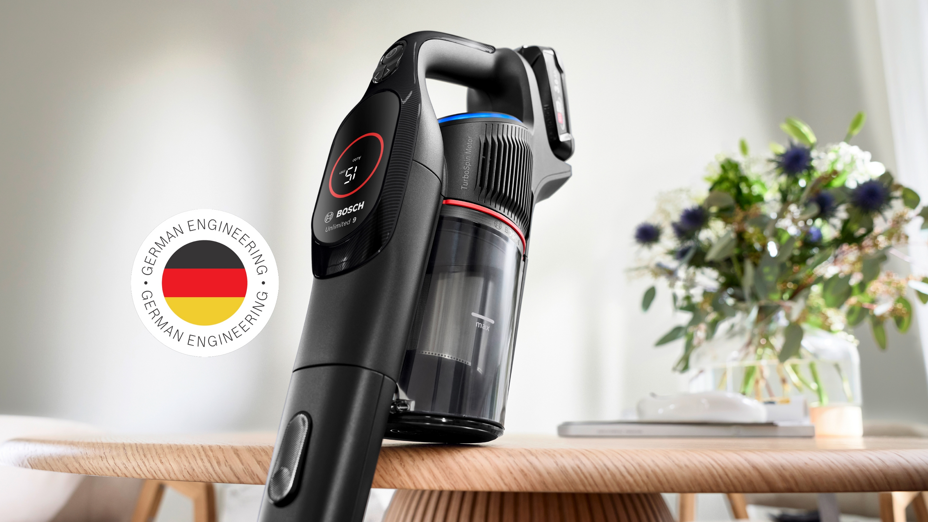 Schwarzer Bosch Akku-Staubsauger mit Digitalanzeige auf Holztisch.