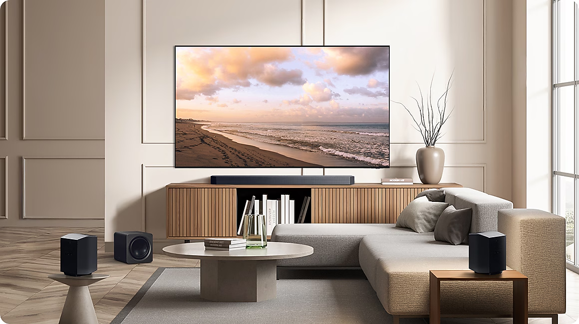 Wohnzimmer mit Strand-TV, Soundbar, Lautsprechern, Sofa und Couchtisch.