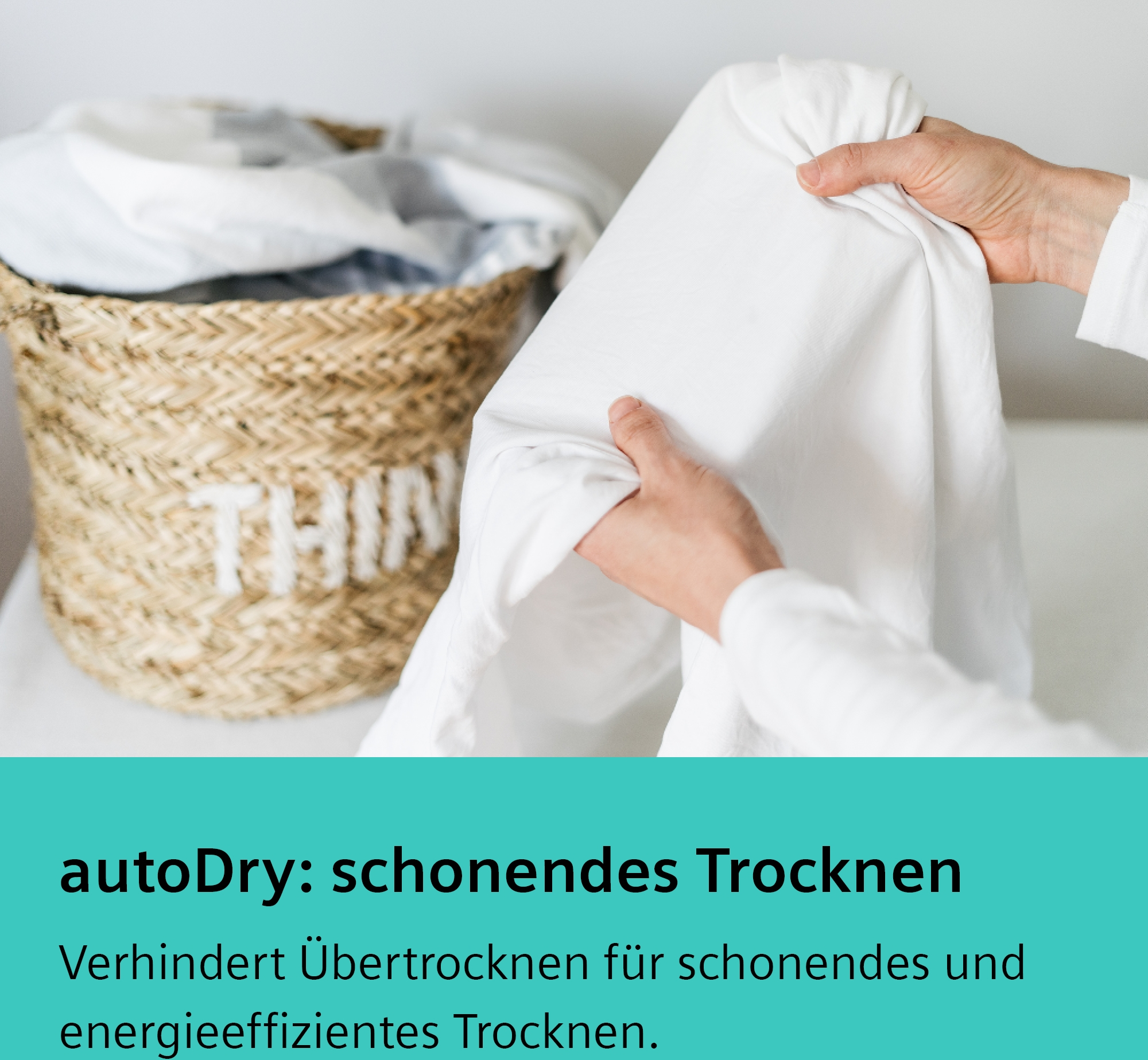 Hände halten weißes Tuch, neben einem Korb mit Wäsche.