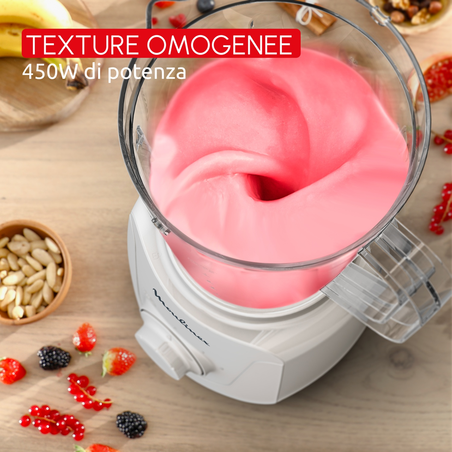 Un robot da cucina con crema rosa e frutti di bosco su tavolo in legno.