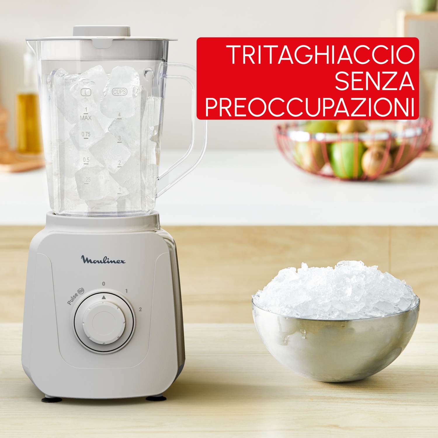 Un tritaghiaccio Moulinex bianco con ghiaccio nella caraffa e una ciotola di ghiaccio tritato accanto.