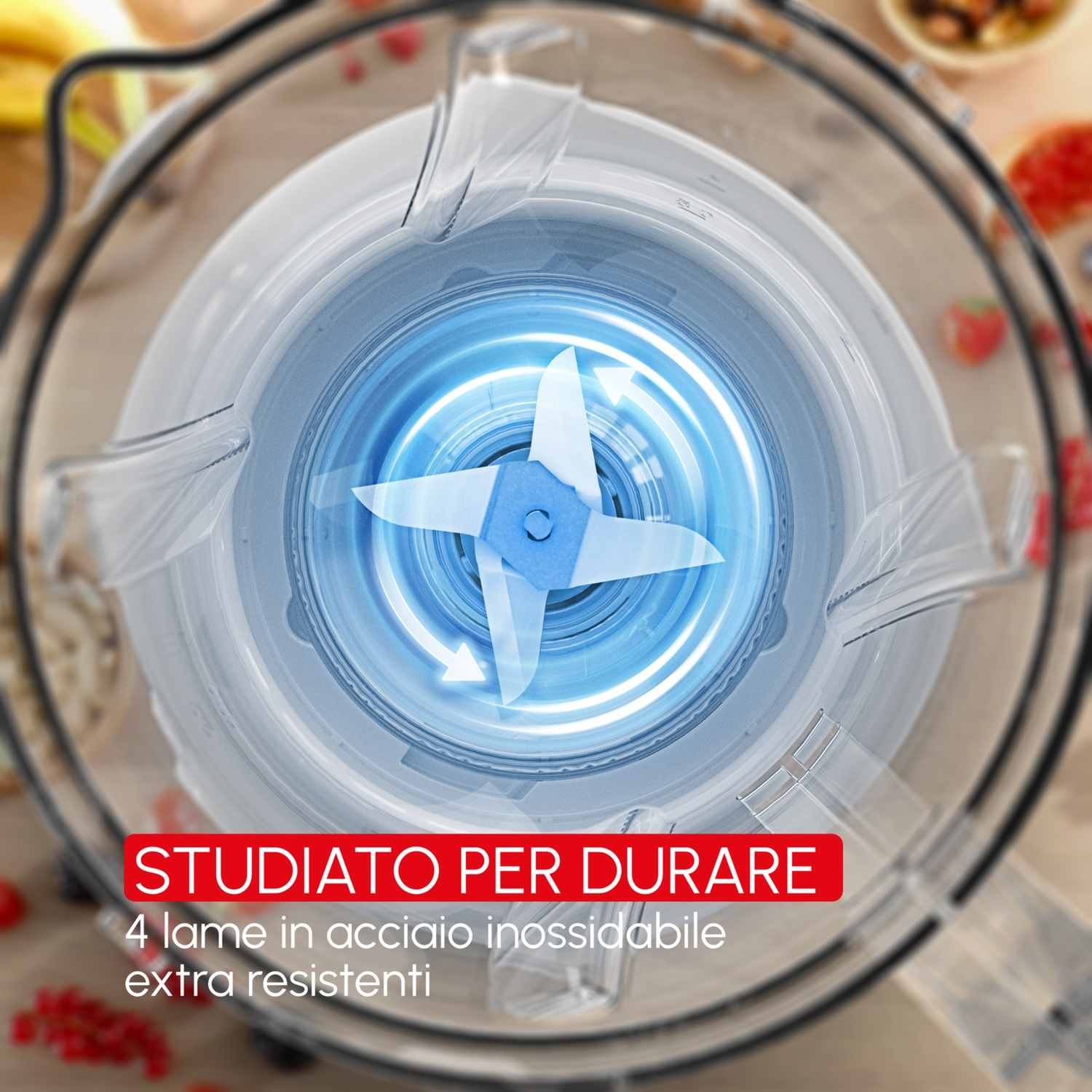 Vista dall'alto di un frullatore con quattro lame in acciaio inox in rotazione.