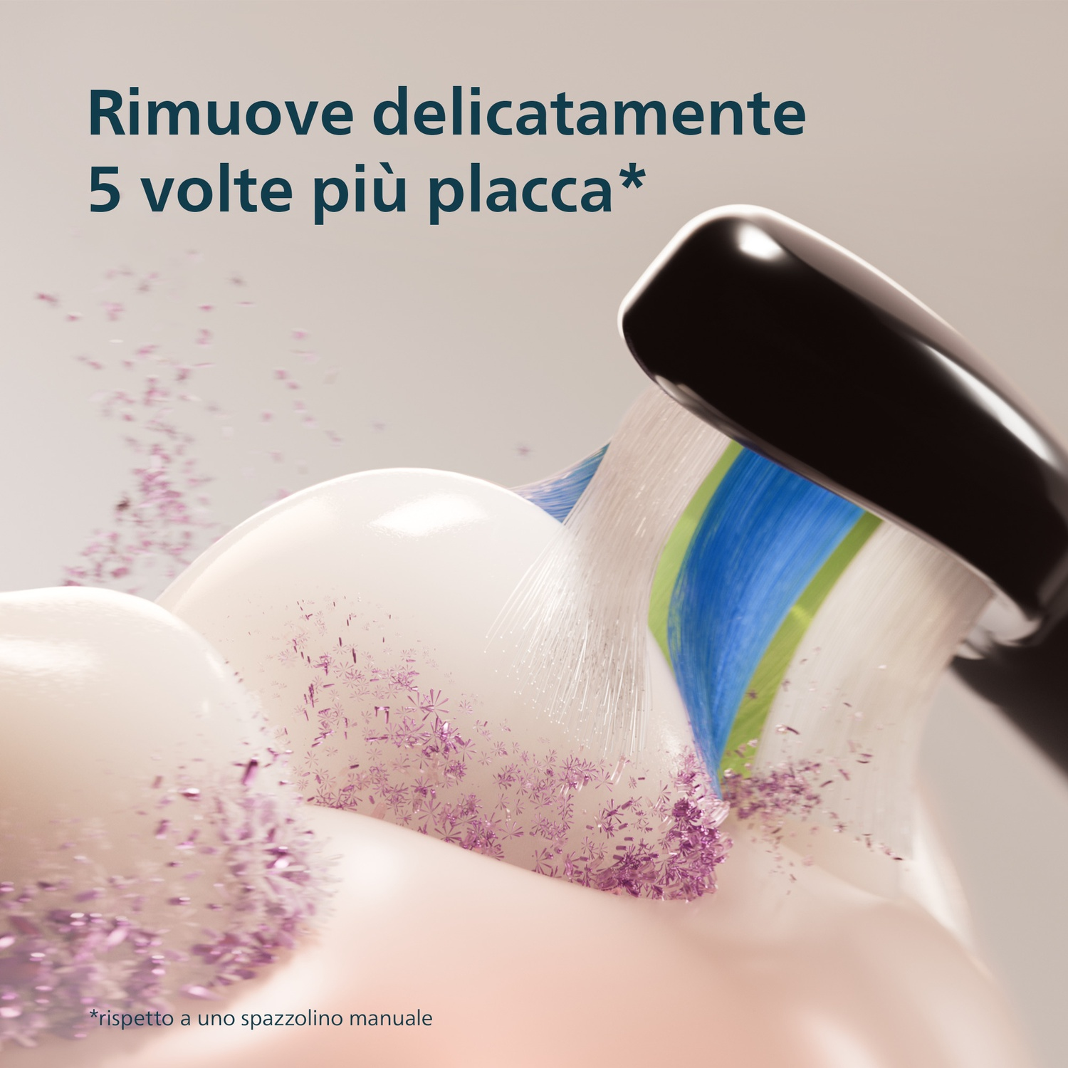 Uno spazzolino elettrico con setole blu e verdi pulisce denti coperti da particelle viola.
