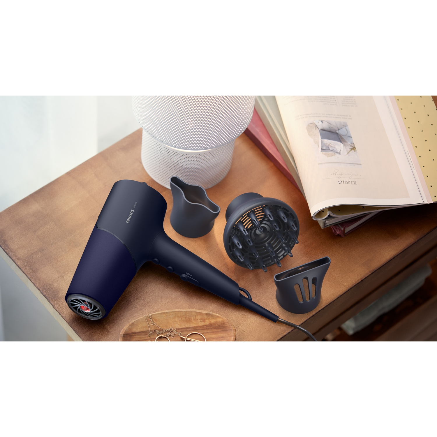 Asciugacapelli Philips blu scuro con accessori su tavolo in legno.