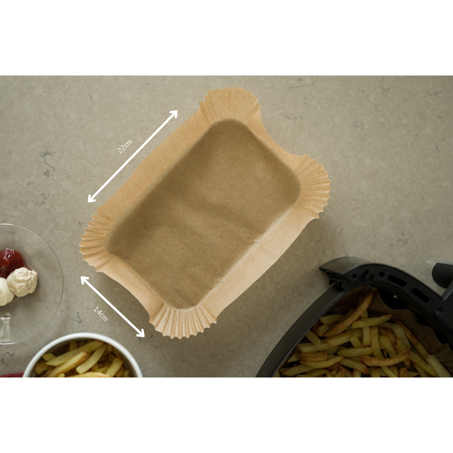 Carta forno marrone per friggitrice ad aria, 22x14cm. Accanto: patatine e condimenti.