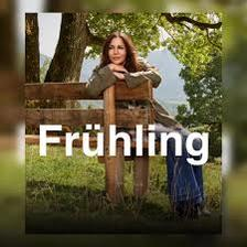 Eine Frau sitzt auf einer Holzbank im Freien, umgeben von Grün.