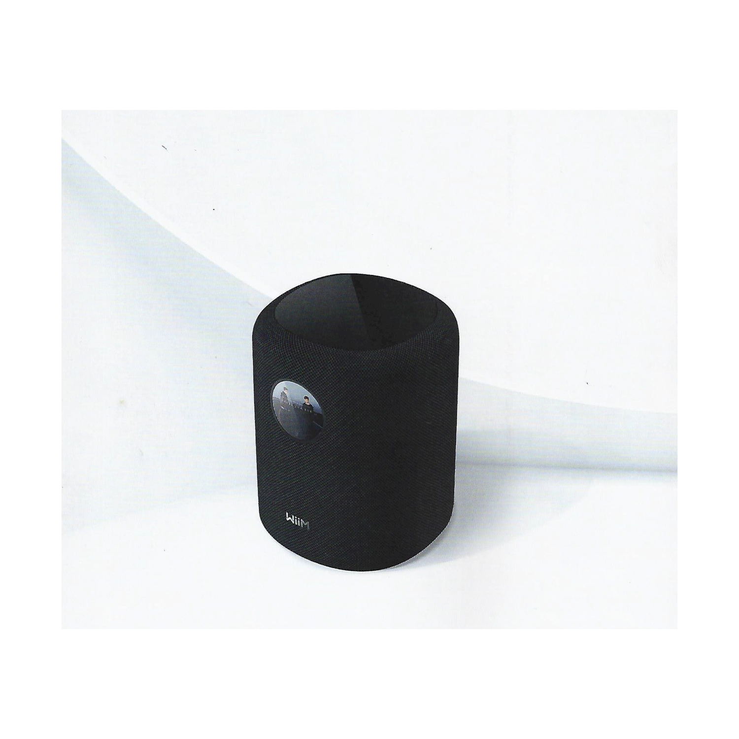 Altoparlante cilindrico nero con cerchio argentato e logo.