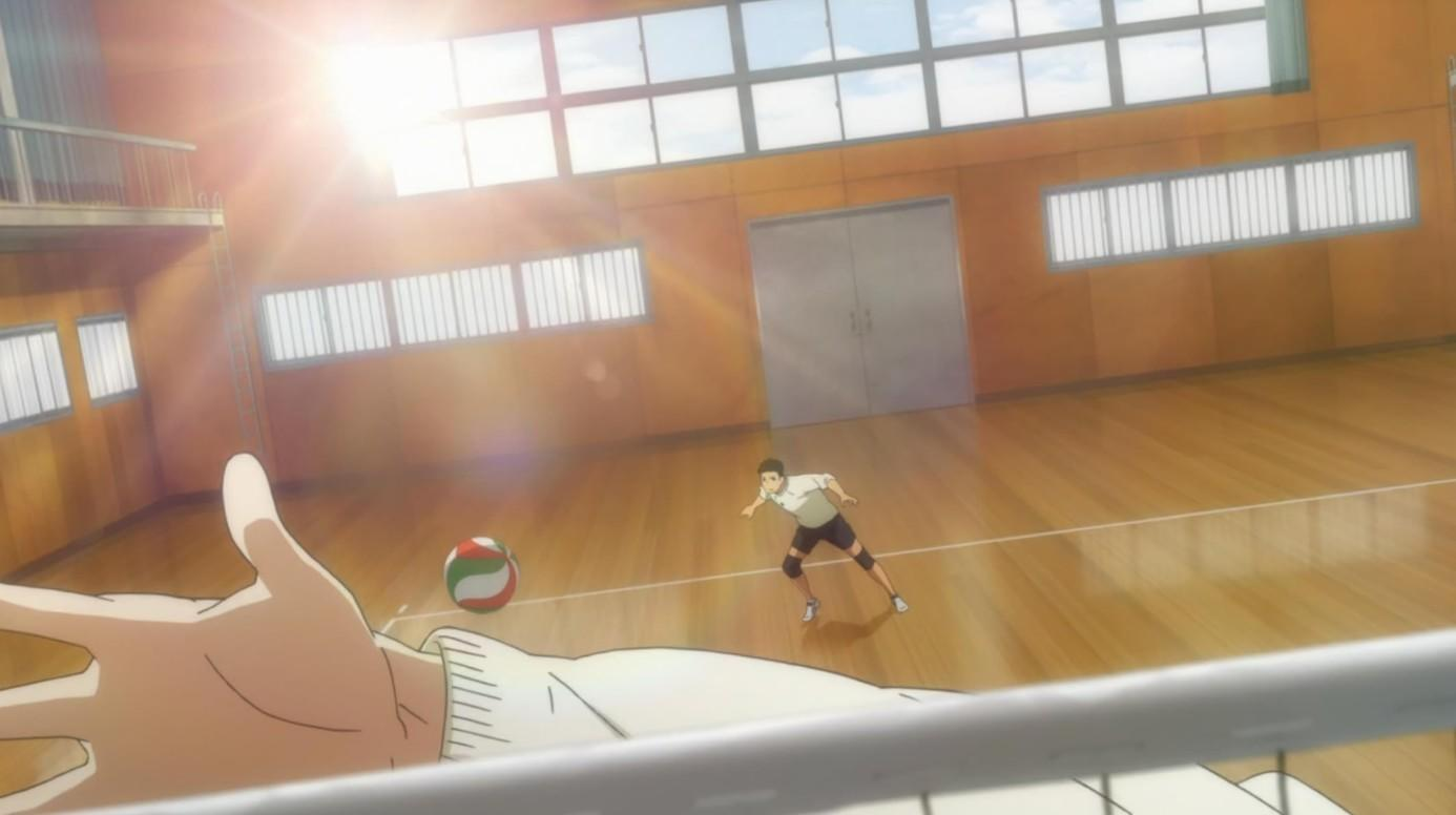 Ein Mann spielt Volleyball in einer Halle mit Holzboden und Fenstern.