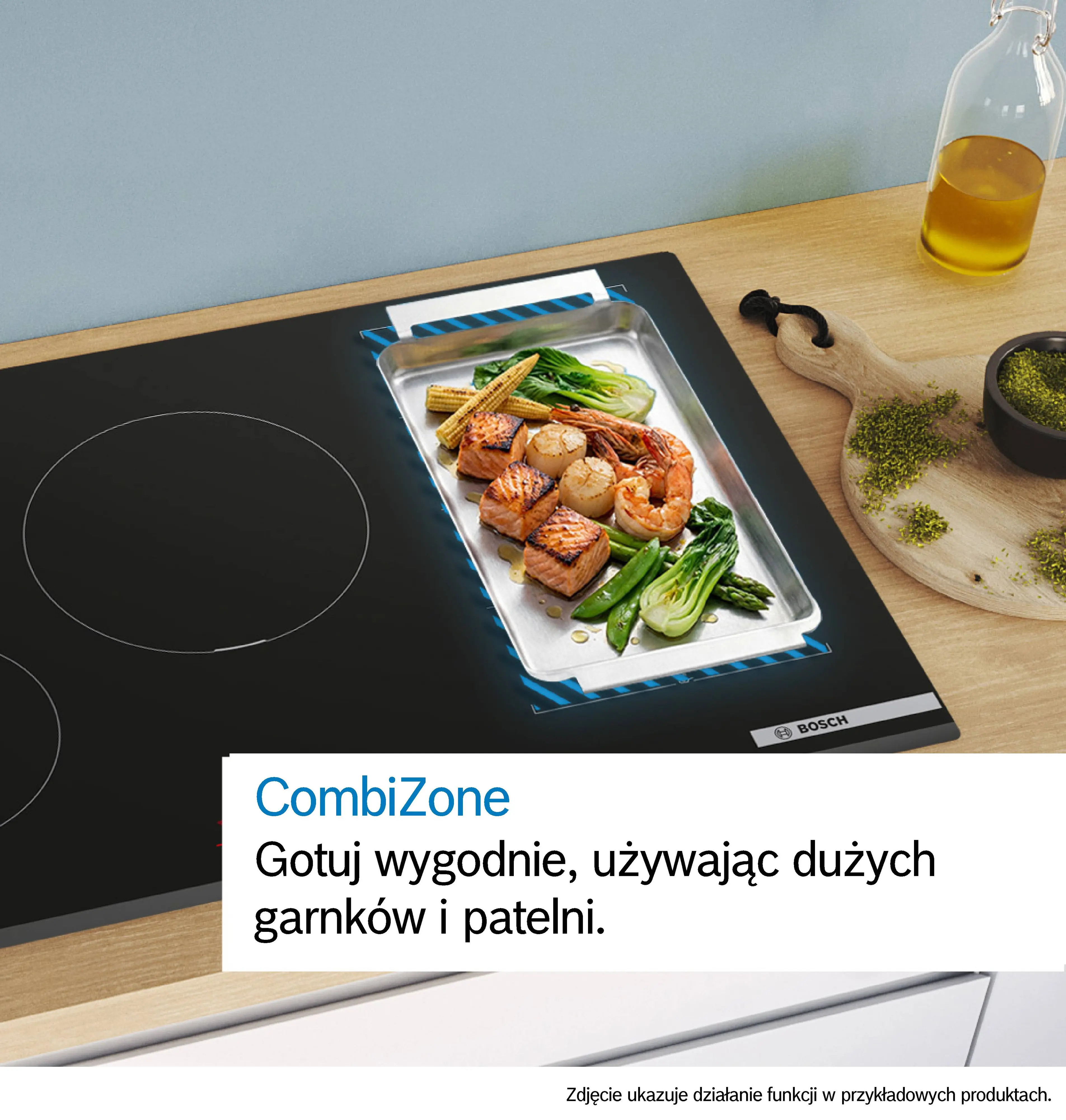 Płyta indukcyjna CombiZone prezentuje łososia, krewetki i warzywa z metalowej tacy.