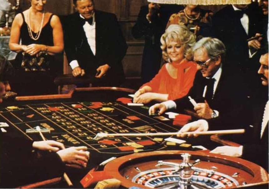 Menschen spielen Roulette in einem eleganten Casino, mit Chips und Karten auf dem Tisch.