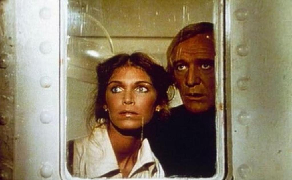 Mann und Frau blicken durch ein Fenster, sie wirken besorgt.