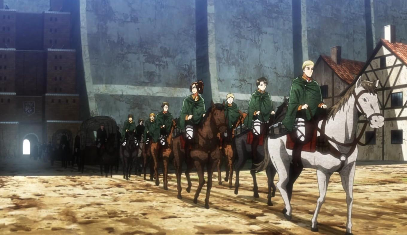 Soldaten in grünen Umhängen reiten auf Pferden vor einer Mauer und Gebäuden.