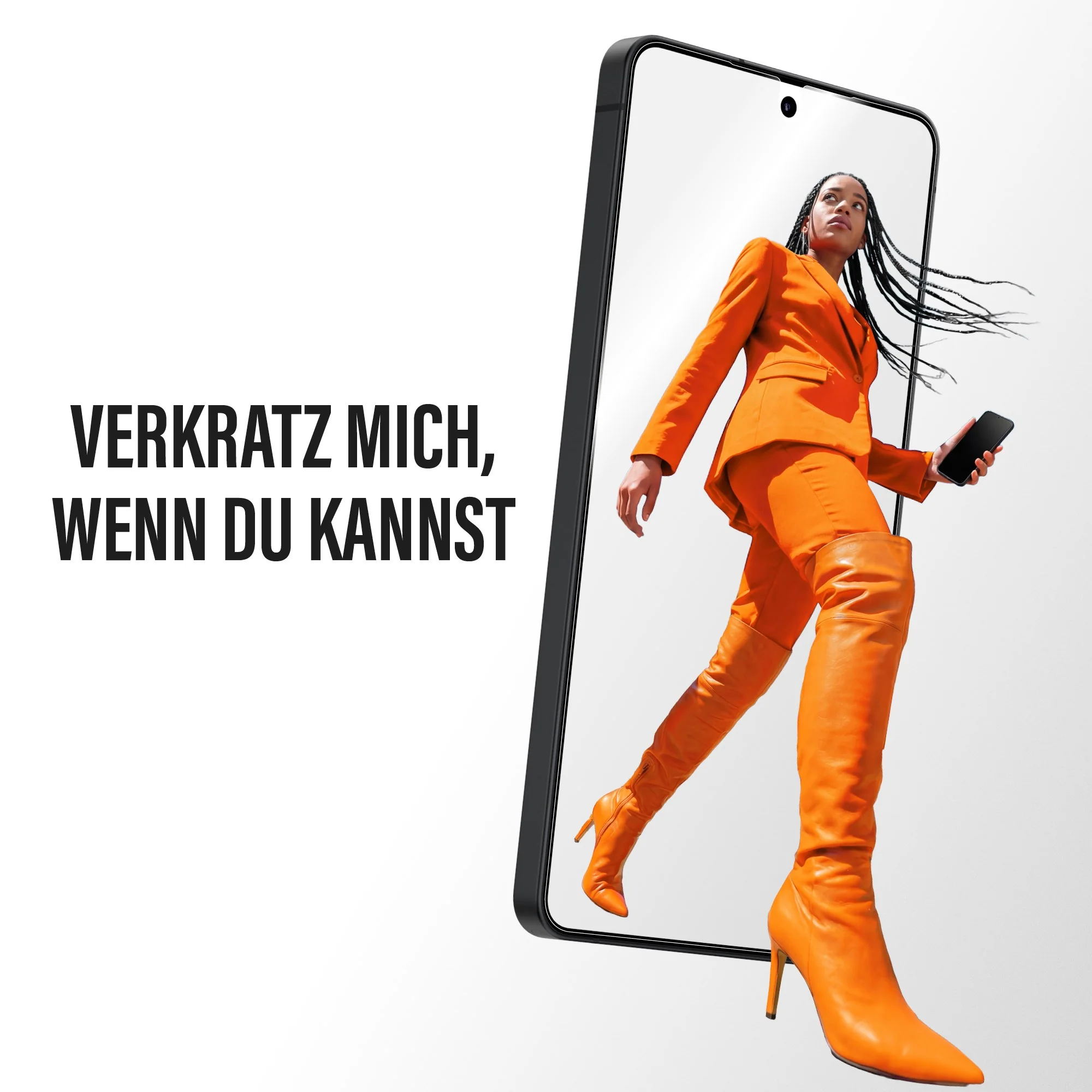 Una donna in abito arancione e stivali tiene uno smartphone dal design moderno.