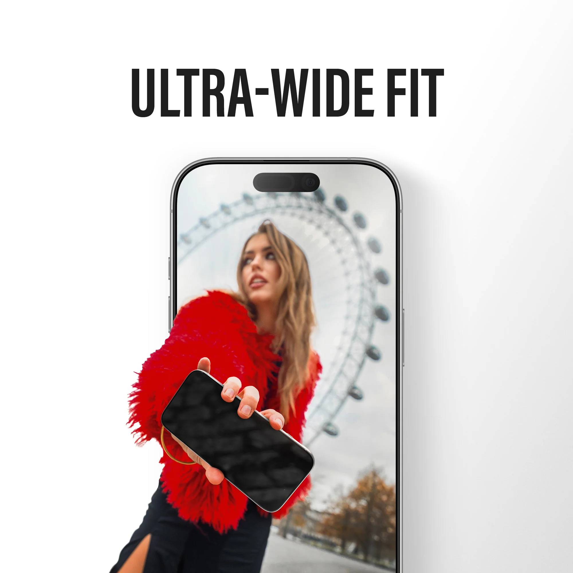 Une femme en manteau rouge tient un smartphone devant une grande roue.