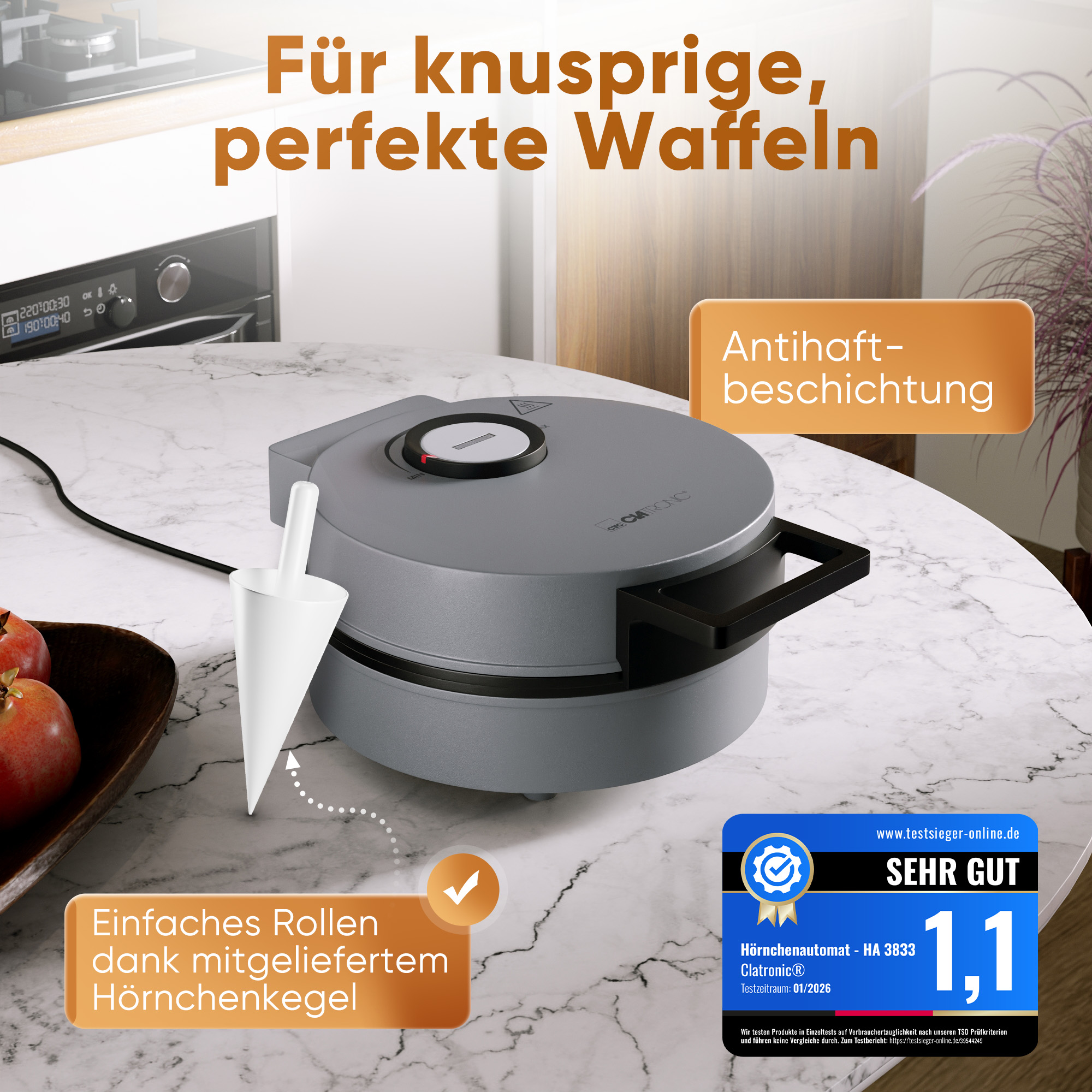 Grauer Waffelautomat mit Hörnchenaufsatz auf Marmortisch. Mit Text "Antihaft-Beschichtung".