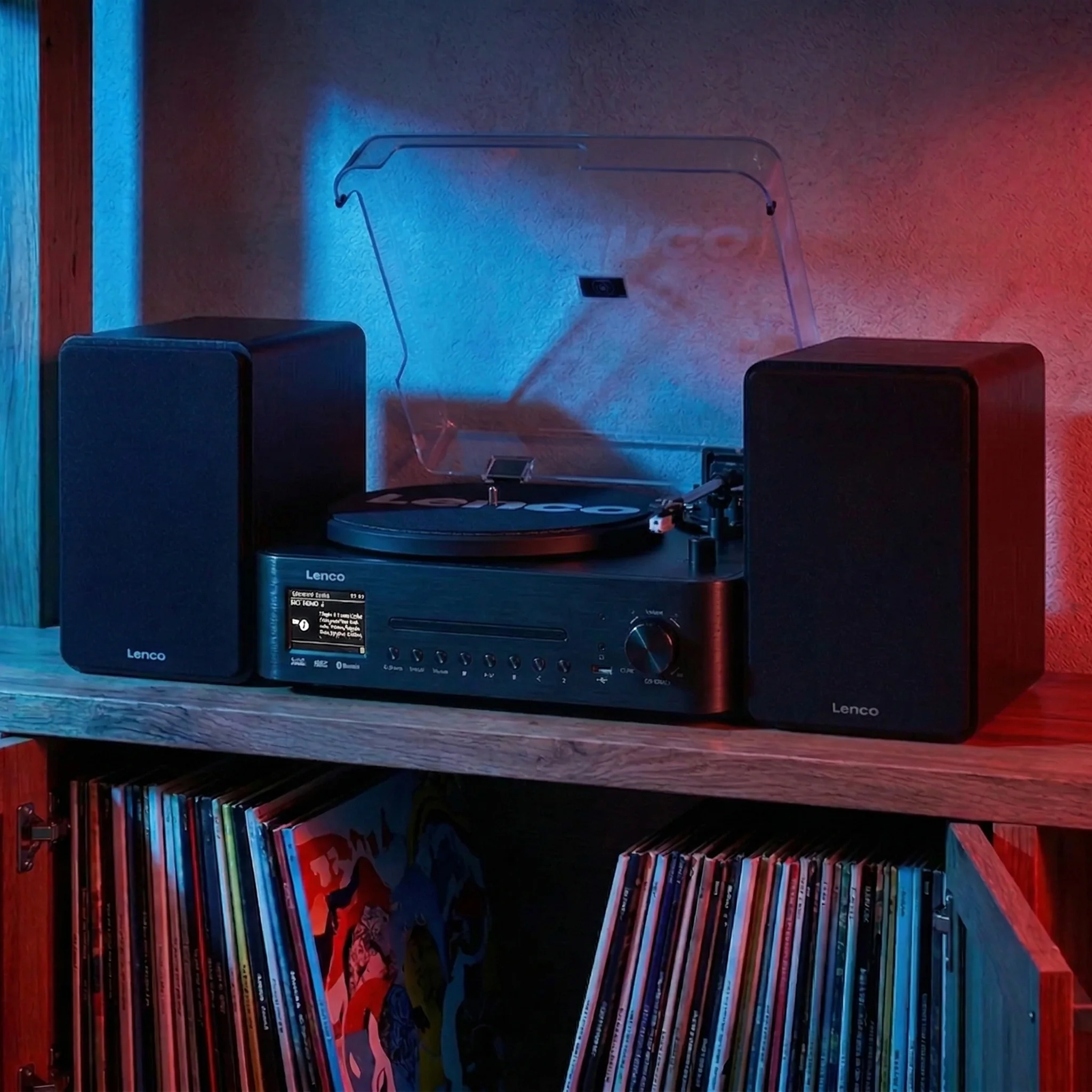 Ein Plattenspieler mit zwei Lautsprechern und CD-Player steht auf einem Regal.