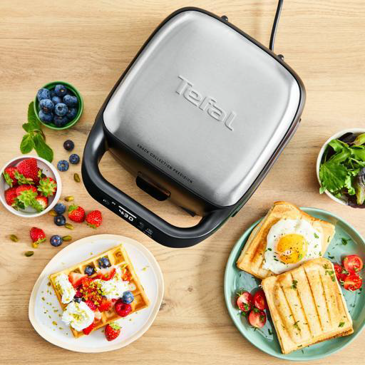 Tostapane Tefal con waffle, toast con uovo e bacche su tavolo legno.