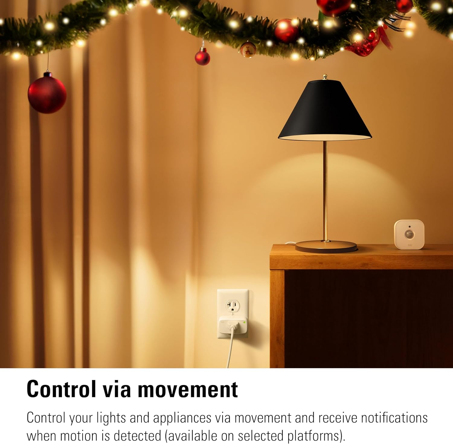 Ein kleiner weißer Bewegungsmelder auf einem Nachttisch neben einer Lampe.