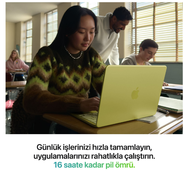 Sınıfta sarı dizüstü bilgisayar kullanan öğrenciler, bir öğretmen izliyor.