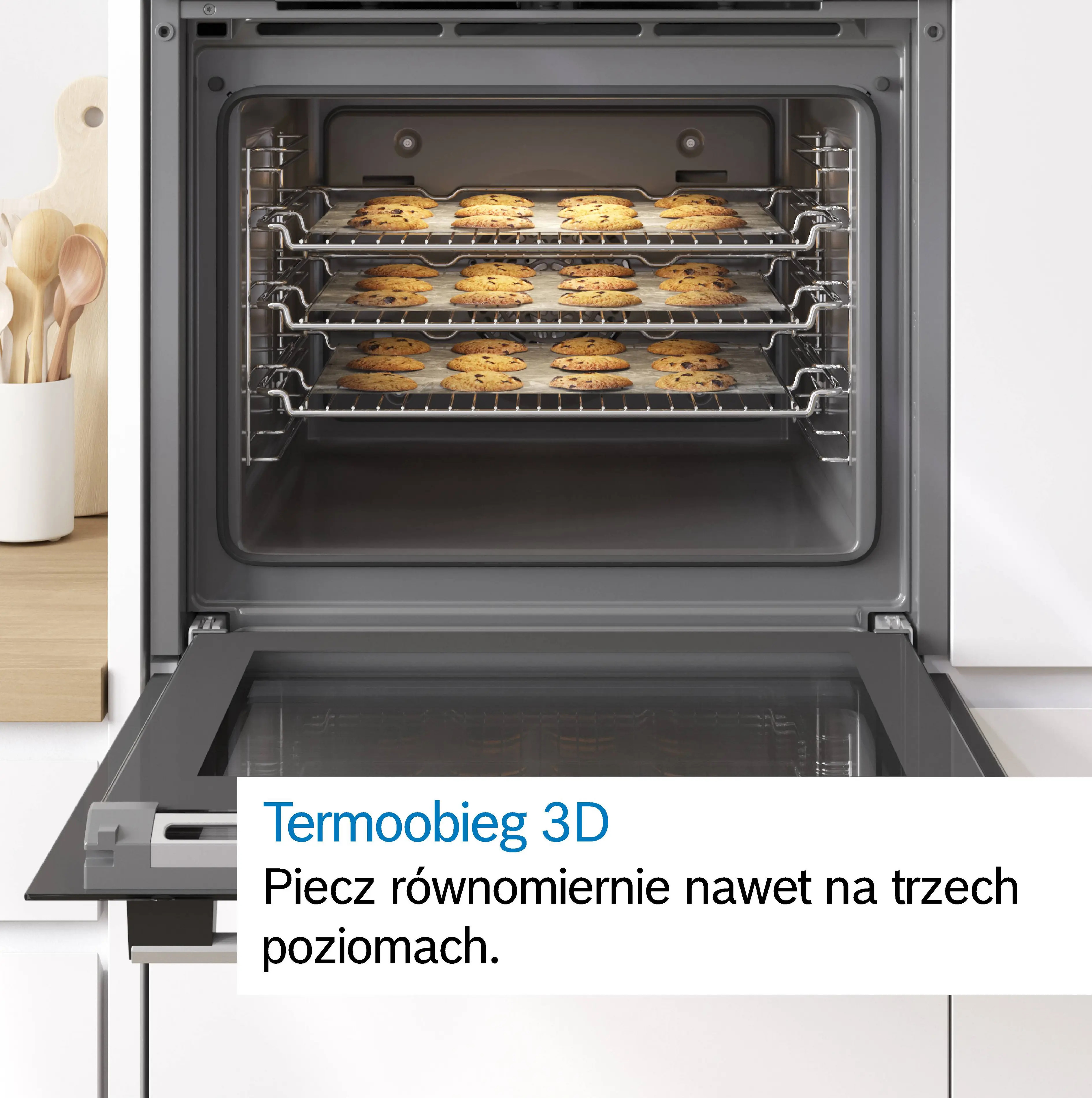 Piekarnik z trzema poziomami wypełnionymi świeżo upieczonymi ciastkami.