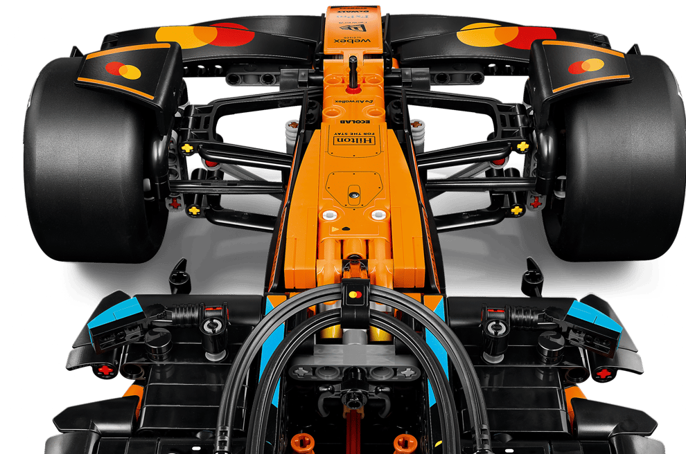 Oberansicht eines orange-schwarzen Lego-Formel-1-Autos mit großen Reifen und Sponsorenaufklebern.