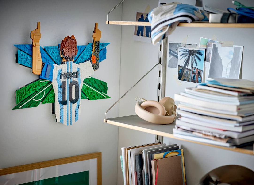 Lego-Messi-Trikot mit Nummer 10 und Flügeln, daneben Kopfhörer und Bücher.