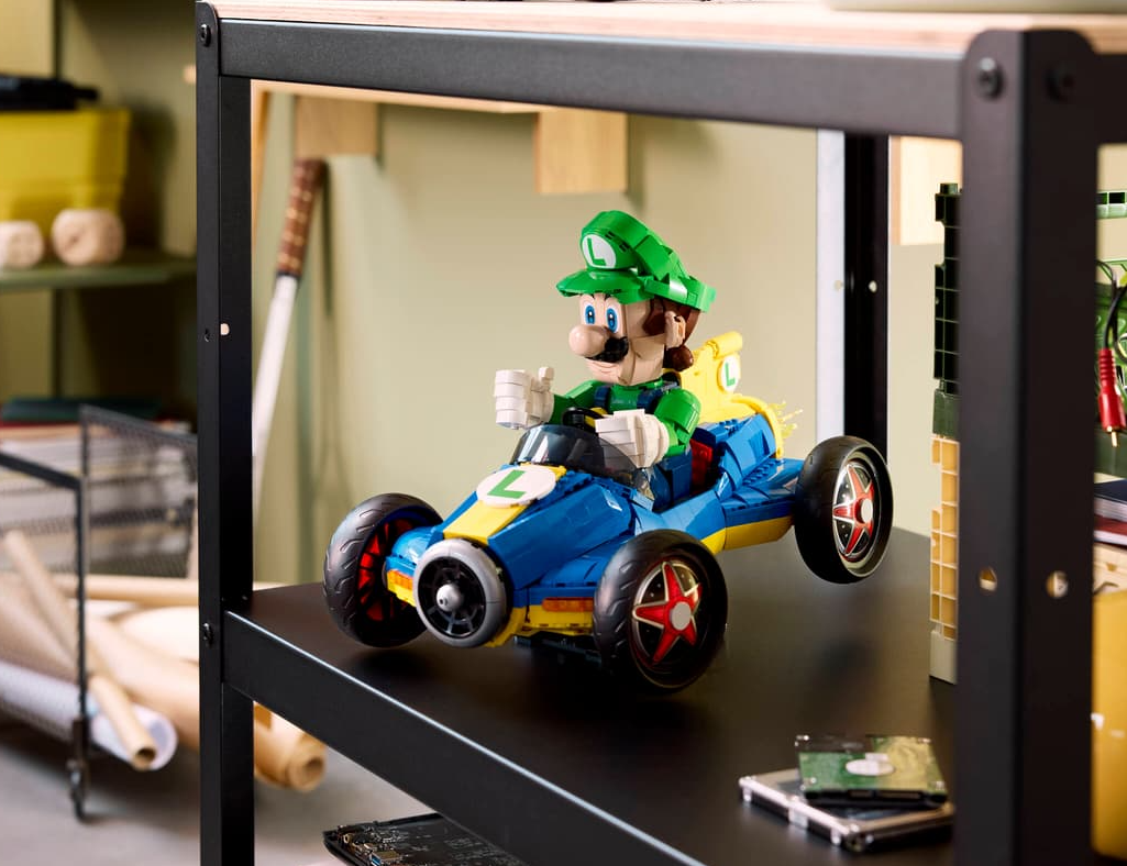 Luigi als Lego-Figur in einem blauen und gelben Go-Kart auf einem schwarzen Regal.