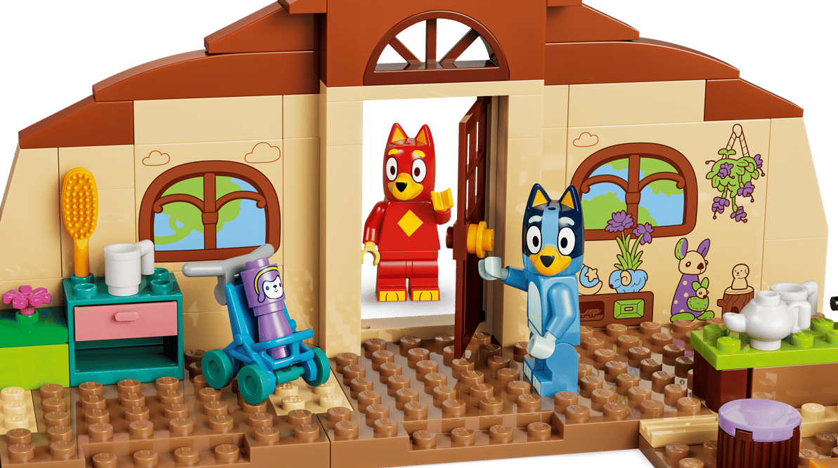 Zwei Hunde-Figuren in einem Lego-Haus mit Möbeln und Spielzeug.