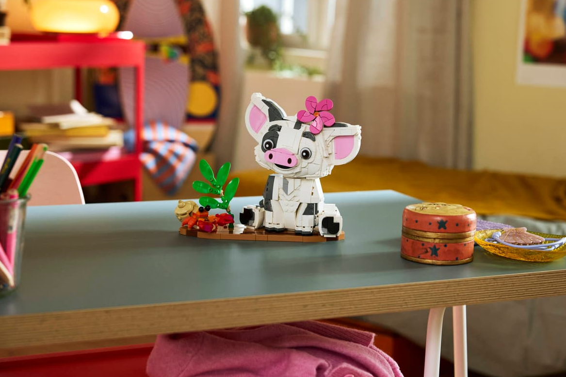 Ein Lego-Modell von Pua, dem Schwein aus Moana, sitzt auf einem Tisch mit Dekorationen.