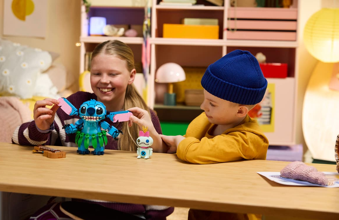 Kinder bauen LEGO Stitch und Scrump auf einem Holztisch.
