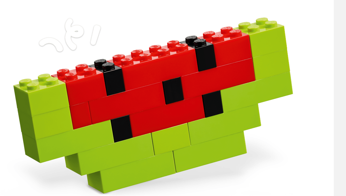 Ein LEGO-Modell einer Wassermelonenscheibe mit roten und schwarzen Steinen für das Fruchtfleisch und grünen Steinen für die Schale.