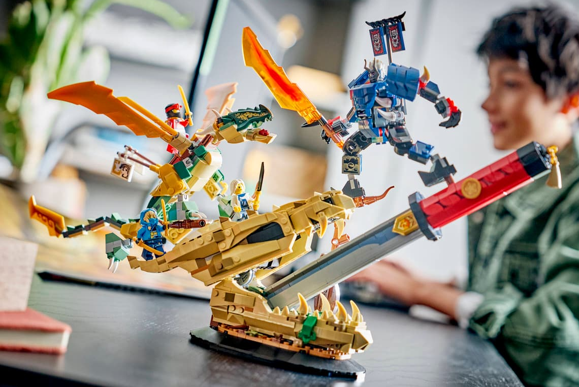 Lego-Ninjas kämpfen mit Drachen und Robotern auf einem Schreibtisch.