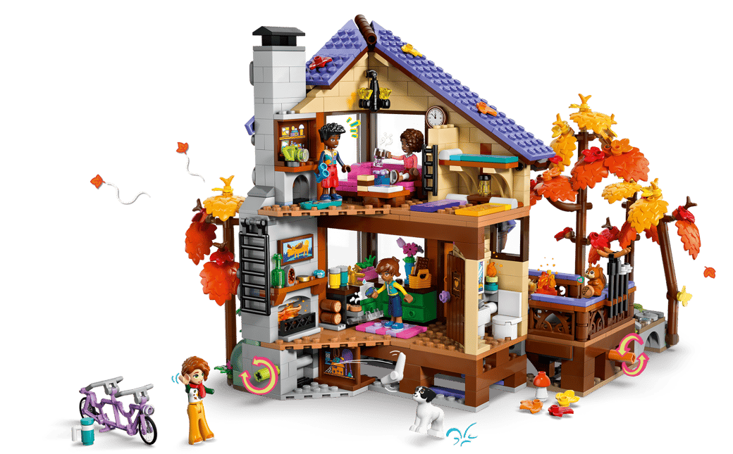 Mehrstöckige Lego-Hütte mit Menschen, einem Fahrrad, Hund und Herbstlaub.