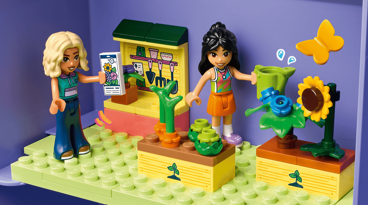 Zwei Lego-Freunde pflegen Pflanzen in einem Garten. Gelbe Schmetterlinge fliegen.
