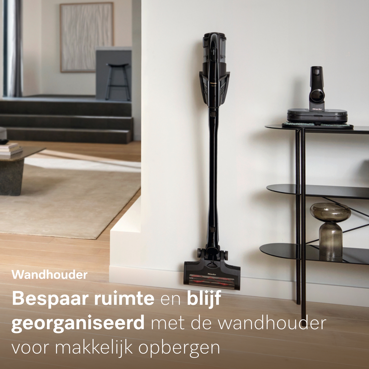 Zwarte kruimeldief aan wandhouder, met accessoires op plank ernaast.