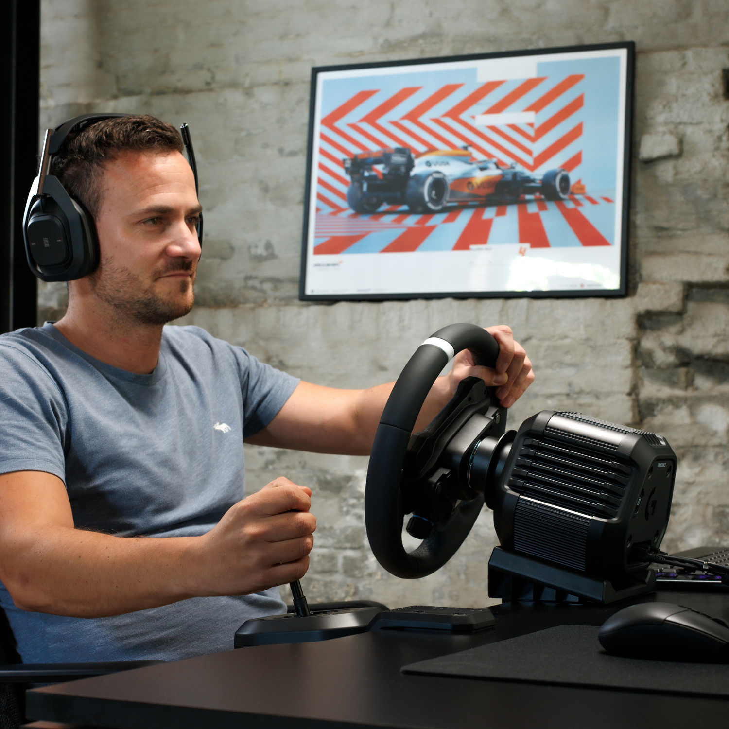 Hombre con auriculares juega juego de carreras con volante y palanca.