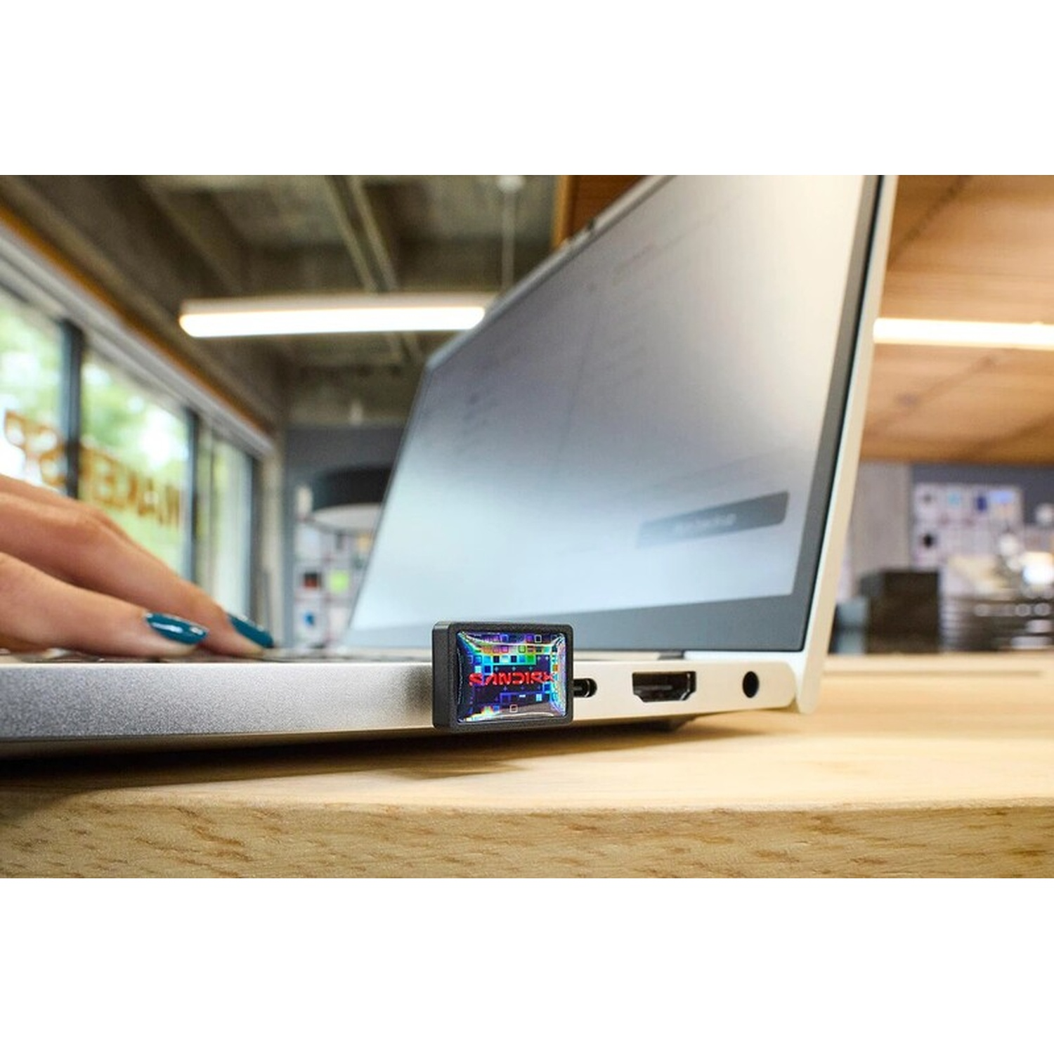 Een USB-adapter met kleurendisplay is aangesloten op een laptop.