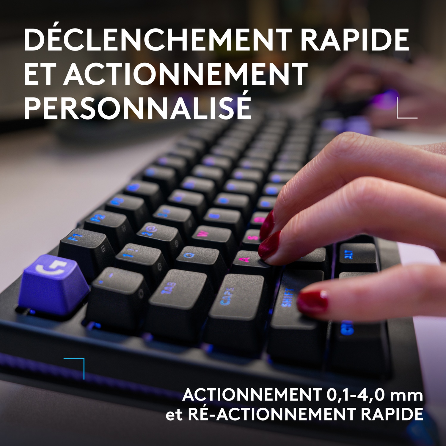 Une personne tape sur un clavier avec des touches bleues et violettes.