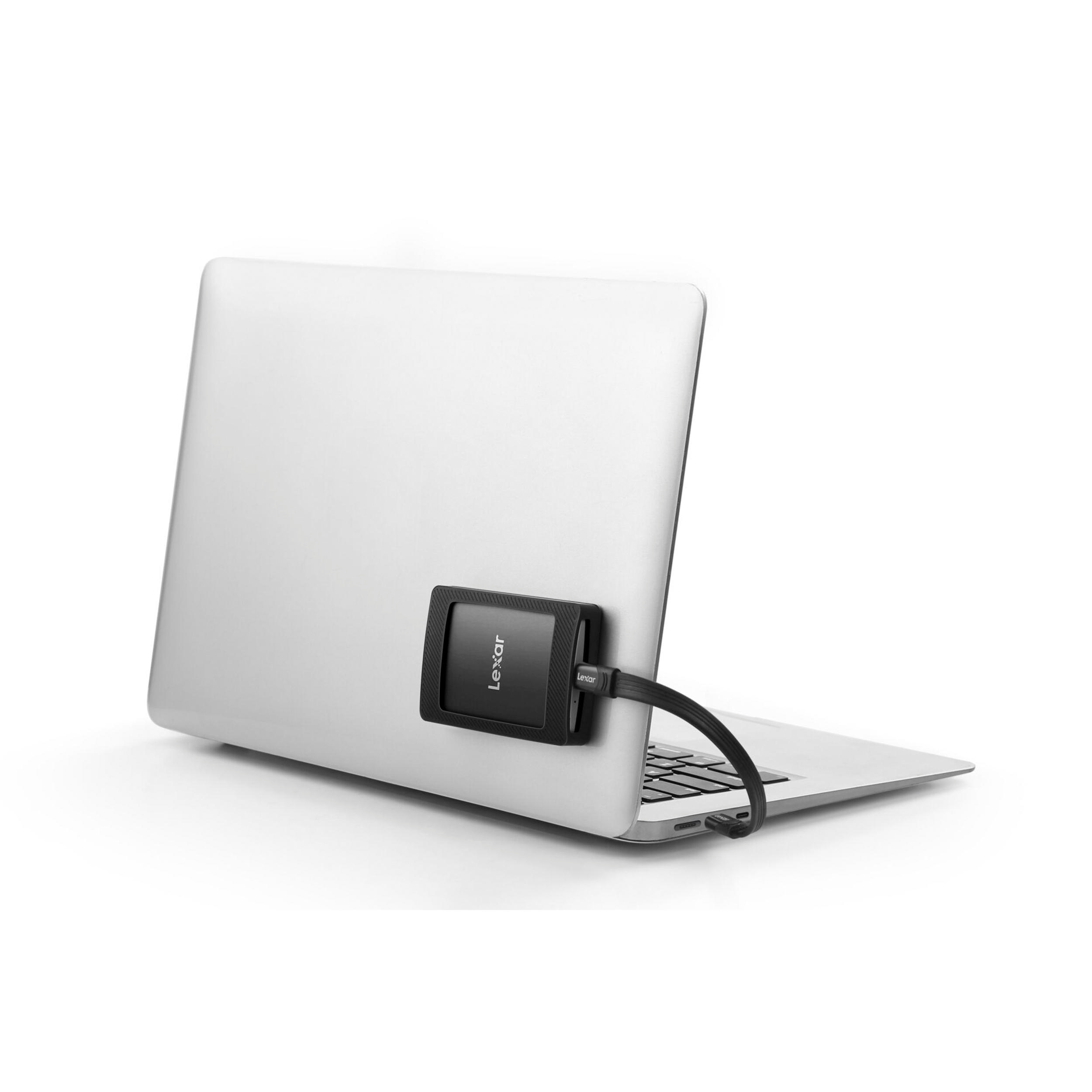 Ein schwarzes externes SSD-Laufwerk ist an einem Laptop befestigt.