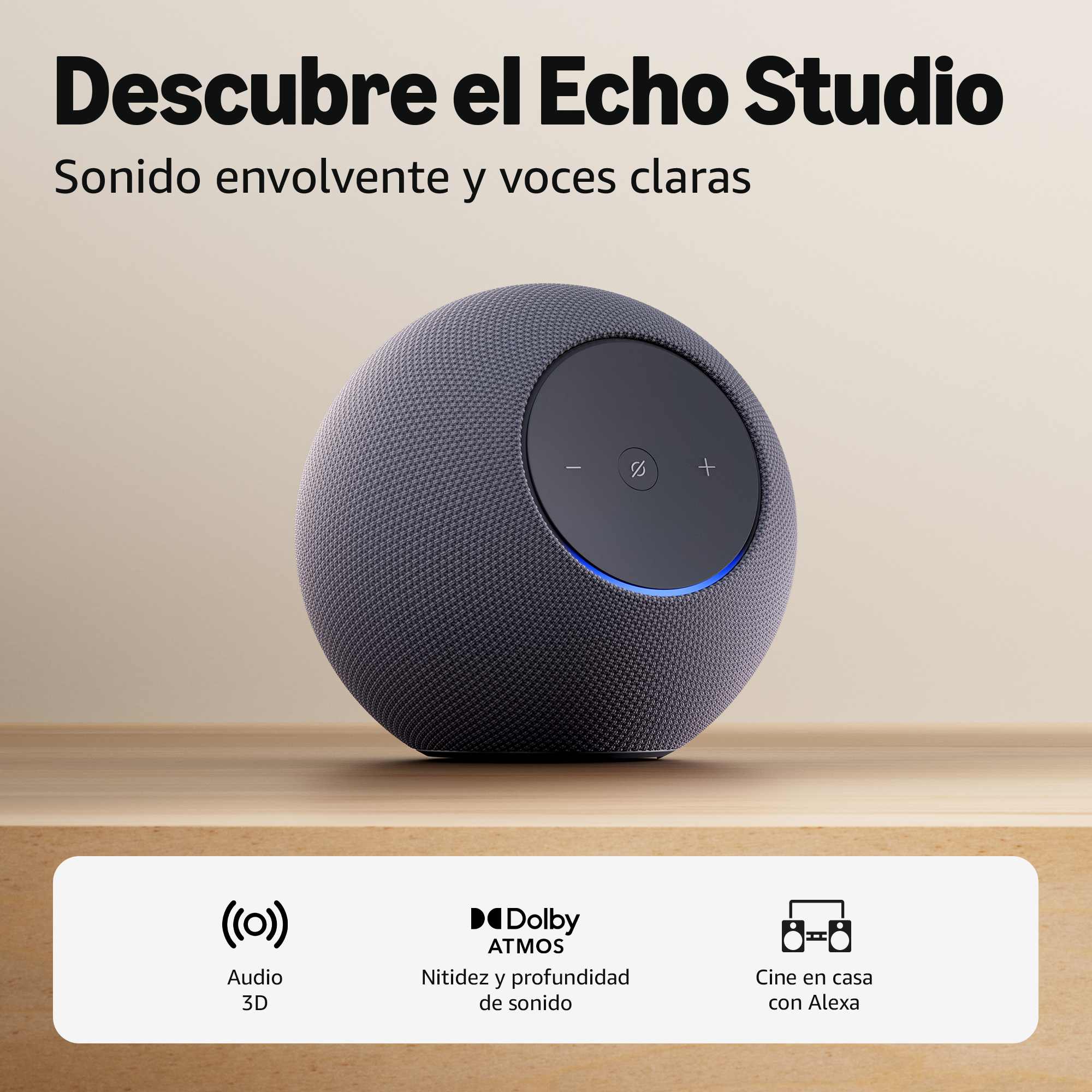 Un altavoz gris Echo Studio con acentos azules sobre una mesa de madera.