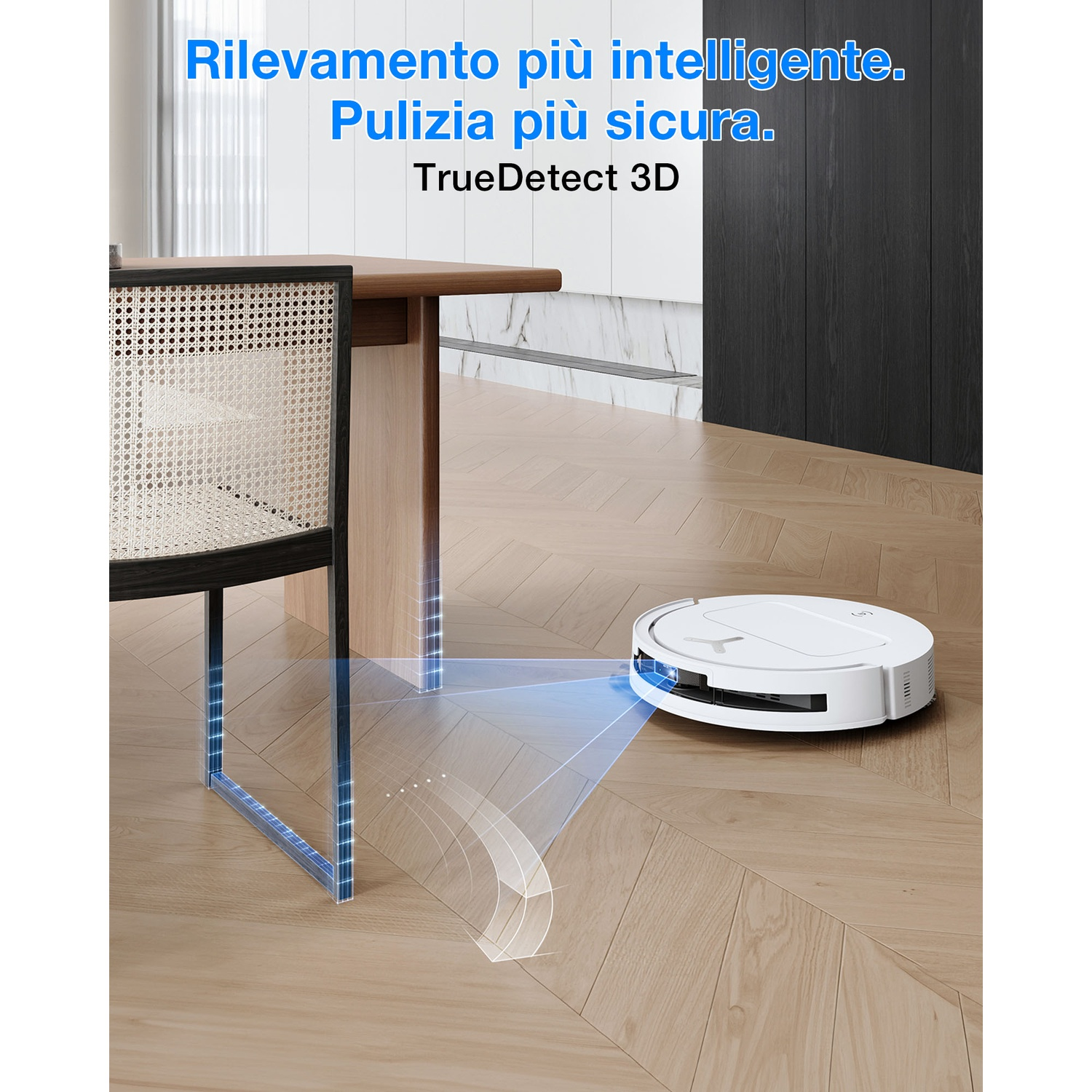 Un robot aspirapolvere bianco pulisce un pavimento in legno vicino a una sedia e un tavolo.