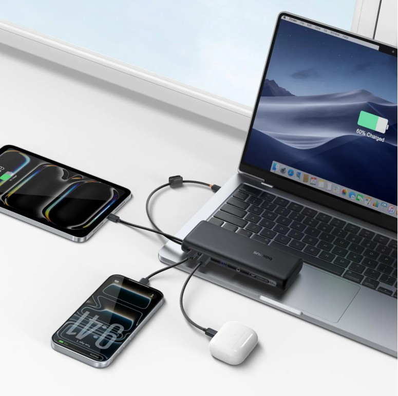 Bir dizüstü bilgisayar, iki telefon ve kulaklık siyah bir göbeğe bağlı.
