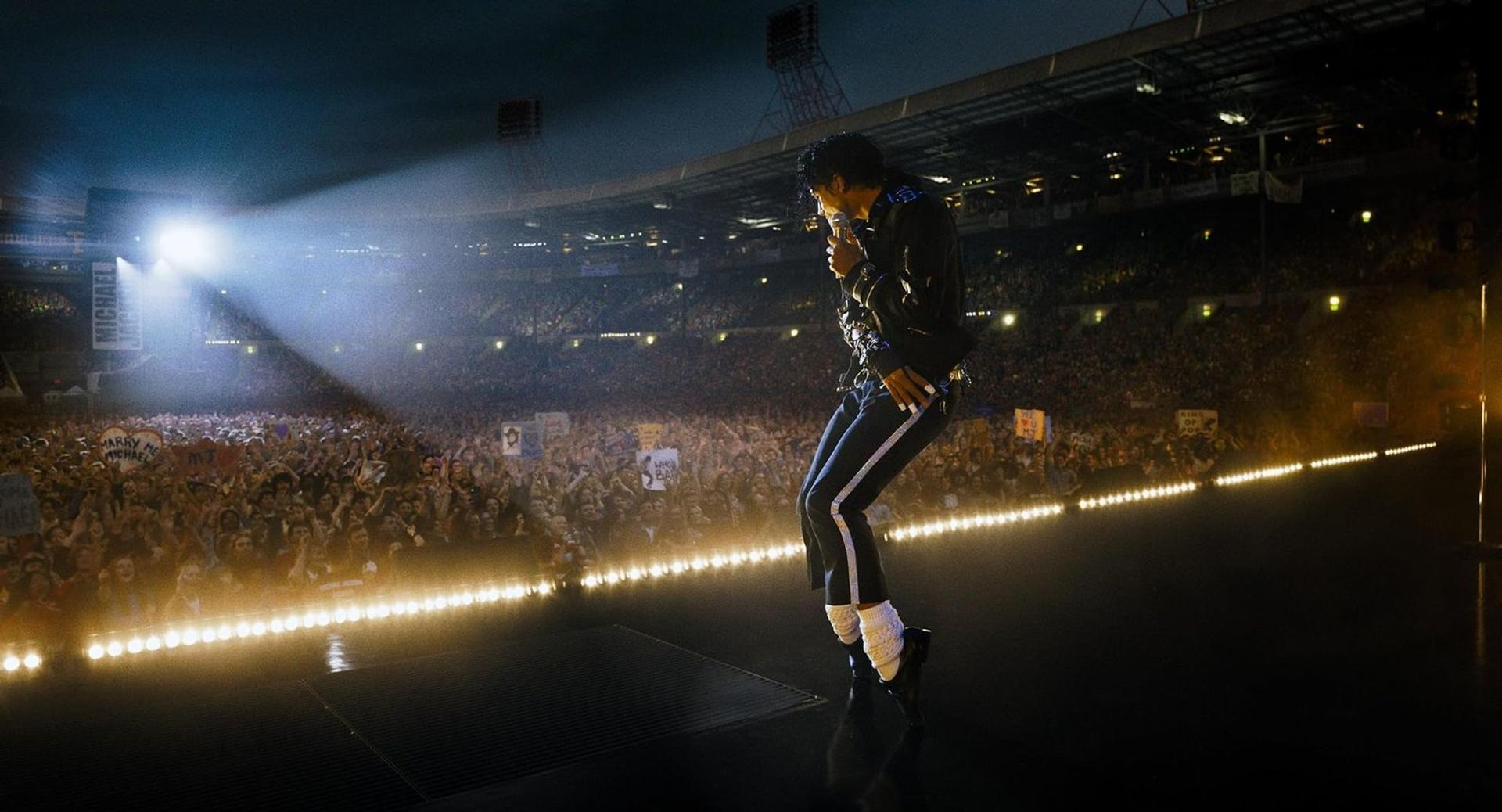 Michael Jackson tritt vor einem großen, jubelnden Publikum in einem Stadion auf.