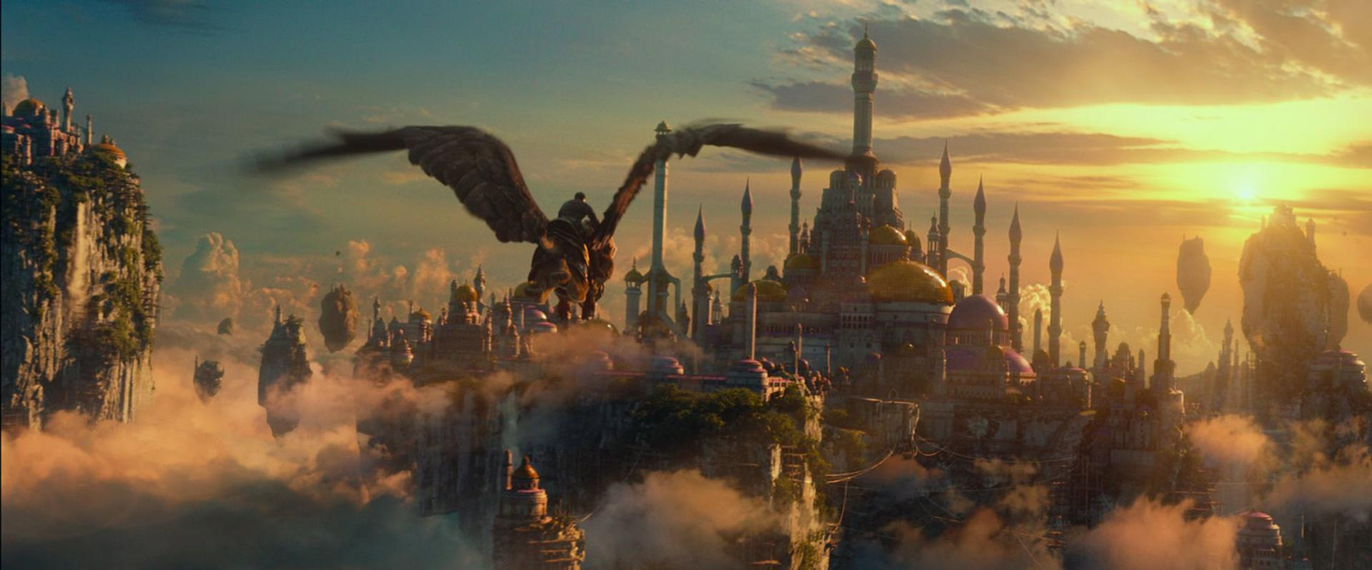 Ein Reiter auf einem Greif fliegt über eine Stadt aus Türmen und Kuppeln im Sonnenuntergang.