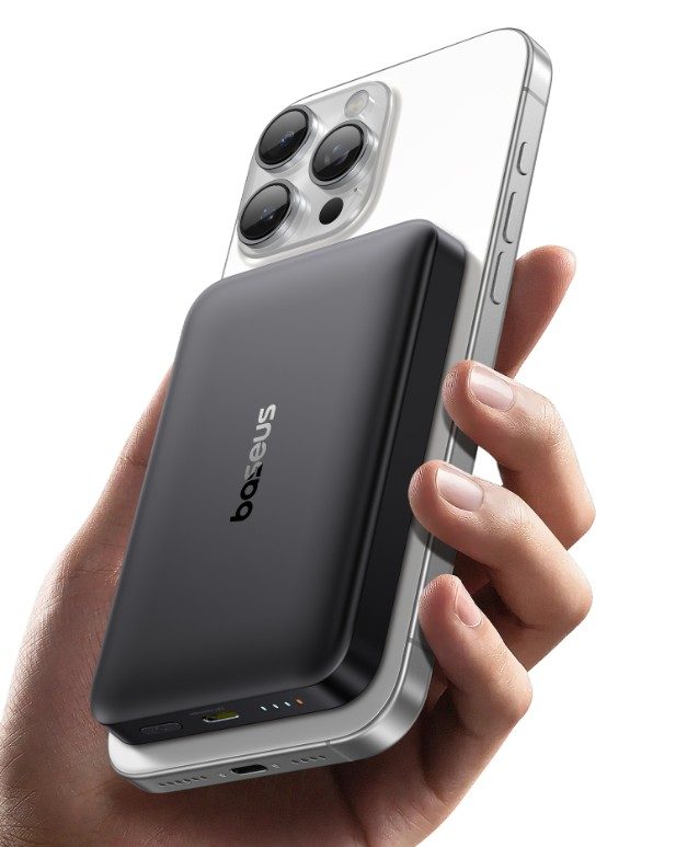 Bir el, gümüş akıllı telefona takılı siyah bir powerbank tutuyor. Powerbankta 'baseus' logosu var.